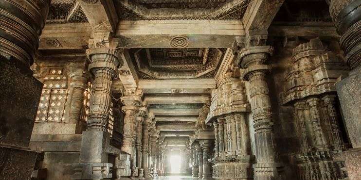 Inside a temple, rows of pillars stretch into the distance, creating a mesmerizing architectural sight.