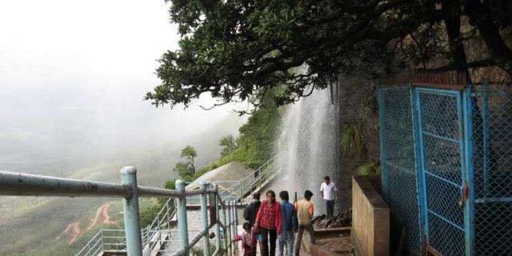 a group of people walking down a stairway Manikyadhara fall in Chikamagalur