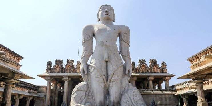 A man statue standing in front of a building, showcasing elegance and strength.