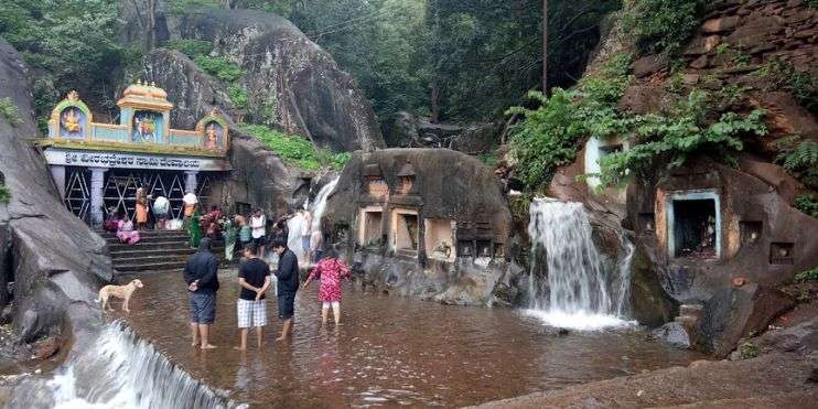 People enjoying Kalhatti Falls, bird watching, swimming in natural pool, picnicking, capturing picturesque scenes, finding peace and solitude.