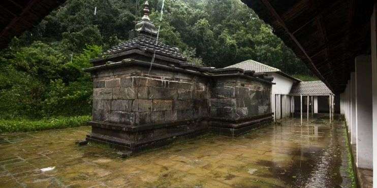 A serene temple nestled among tall trees in a lush forest.