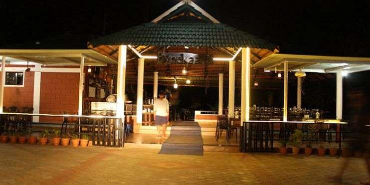 A bustling restaurant at night, with people strolling by, enjoying the lively atmosphere and delicious food.