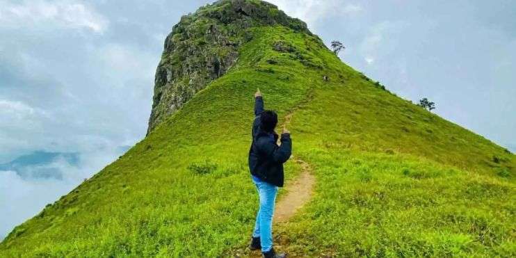 A person standing on a mountain peak, arms outstretched, feeling victorious and free.
