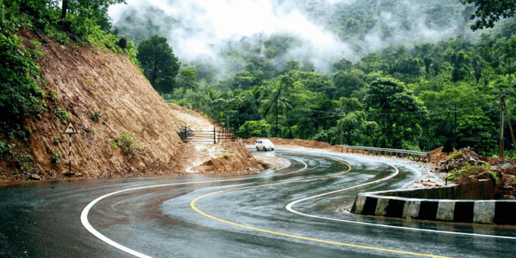 A car driving on a winding mountain road.