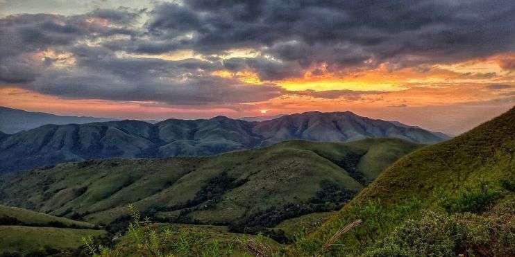 Sunset over the majestic mountains in the Philippines, painting the sky with vibrant hues of orange, pink, and purple.