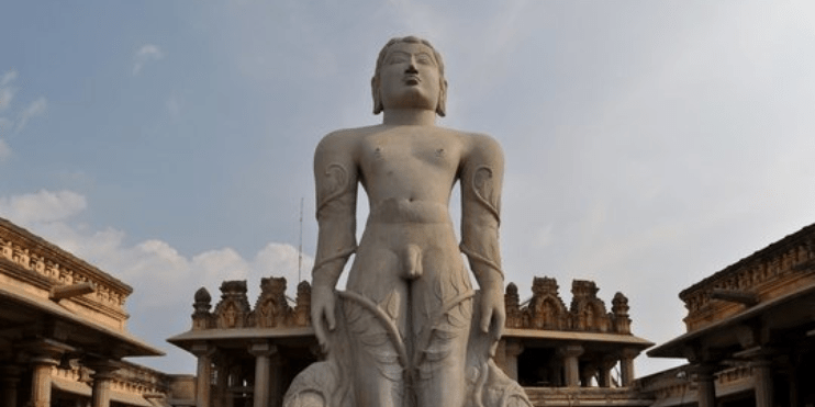 A man statue standing in front of a building, showcasing elegance and strength.