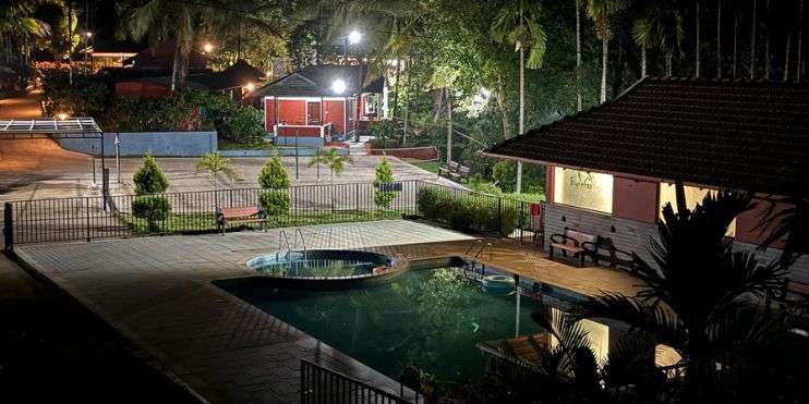 A night view of the illuminated pool at Bynekaadu resort, nestled in the lush landscapes near Bandaje Falls.