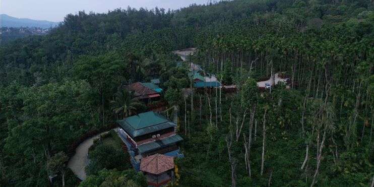 Aerial view of Bynekaadu resort amidst lush coffee plantations in Chikmagalur, offering luxurious accommodations and top-notch amenities.