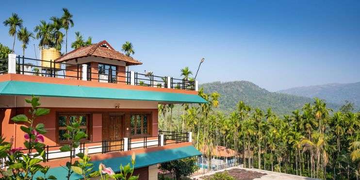 A house with a balcony overlooking mountains. Stay at Bynekaadu Resort and savor local cuisine.