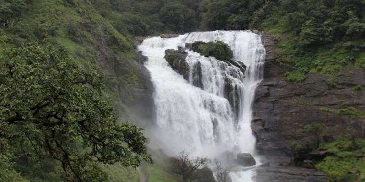 A stunning 168-meter waterfall, Hebbe Falls, cascades in a lush green forest, creating a spectacular visual display.