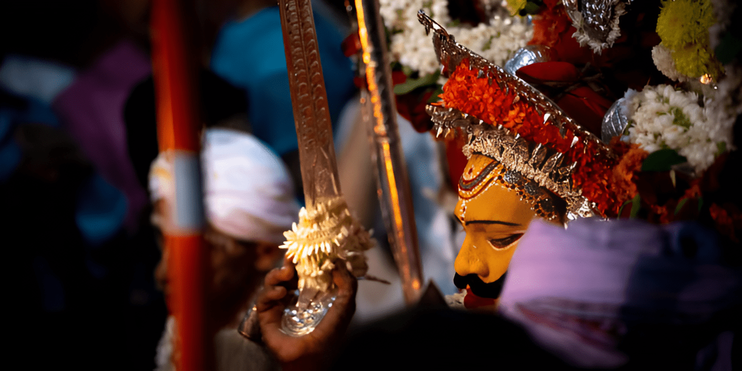 An elderly man plays a drum amidst a lively crowd at the culturally rich Kailash Fair near Chikmagalur.