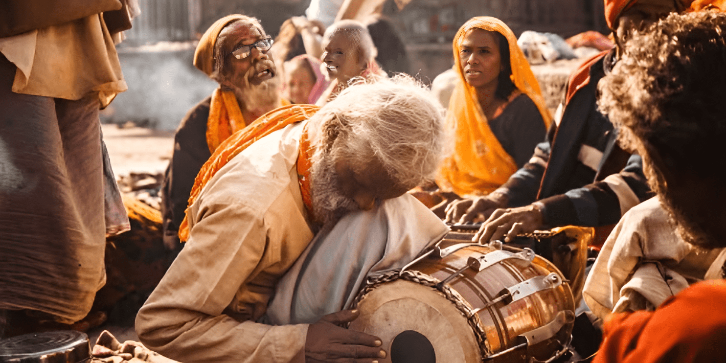 An elderly man plays a drum amidst a lively crowd at the culturally rich Kailash Fair near Chikmagalur.