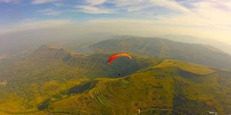 A paraglider navigates the skies over Chikmagalur's mountains, capturing the beauty of the Western Ghats from an aerial perspective.