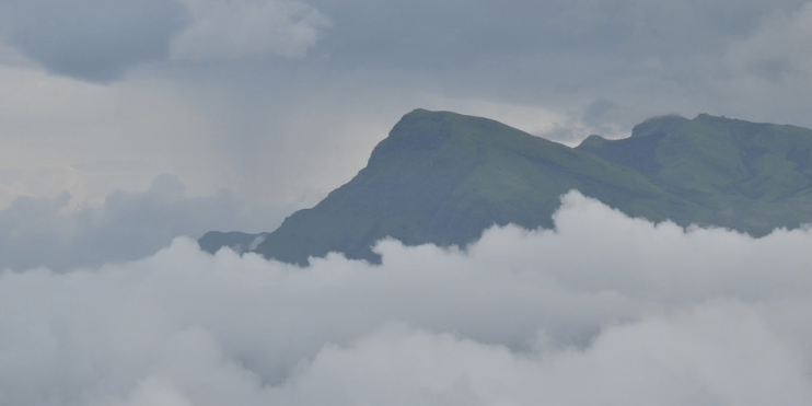 Scenic view from a mountain in Sri Lanka, showcasing vibrant sunset colors of red, orange, and pink against clear skies.