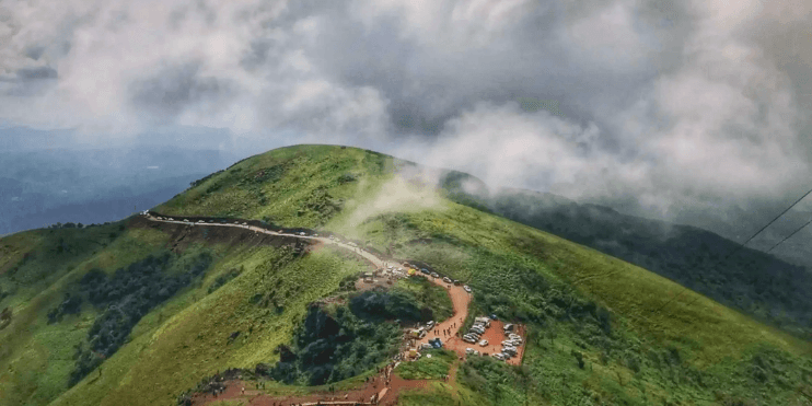 A mountain peak with a winding road atop, showcasing the serene beauty of sunrise over the Western Ghats.