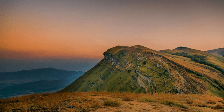 A stunning mountain silhouette against a vibrant sunset, showcasing the beauty of Z Point near Chikmagalur.