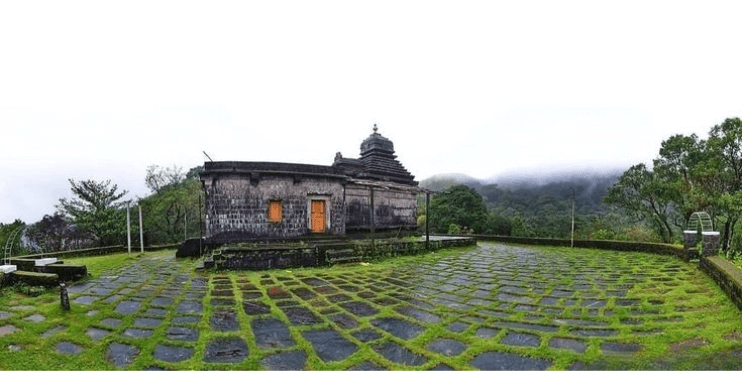 A small temple surrounded by lush greenery, offering a serene atmosphere for meditation and spiritual reflection.