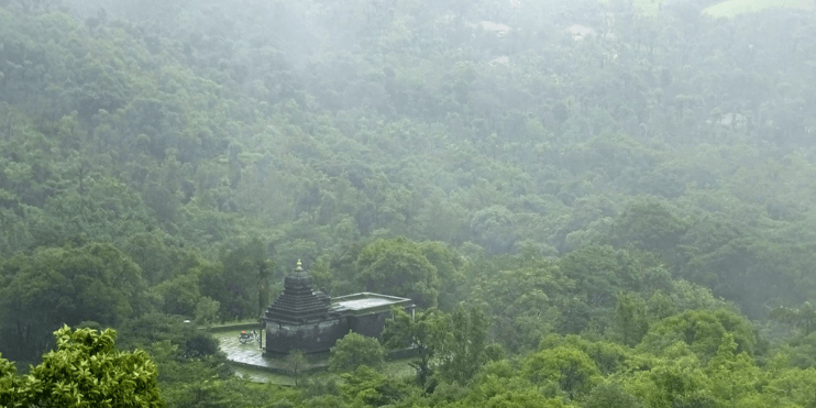 A small temple nestled in a vibrant green forest, symbolizing spiritual heritage and local folklore.