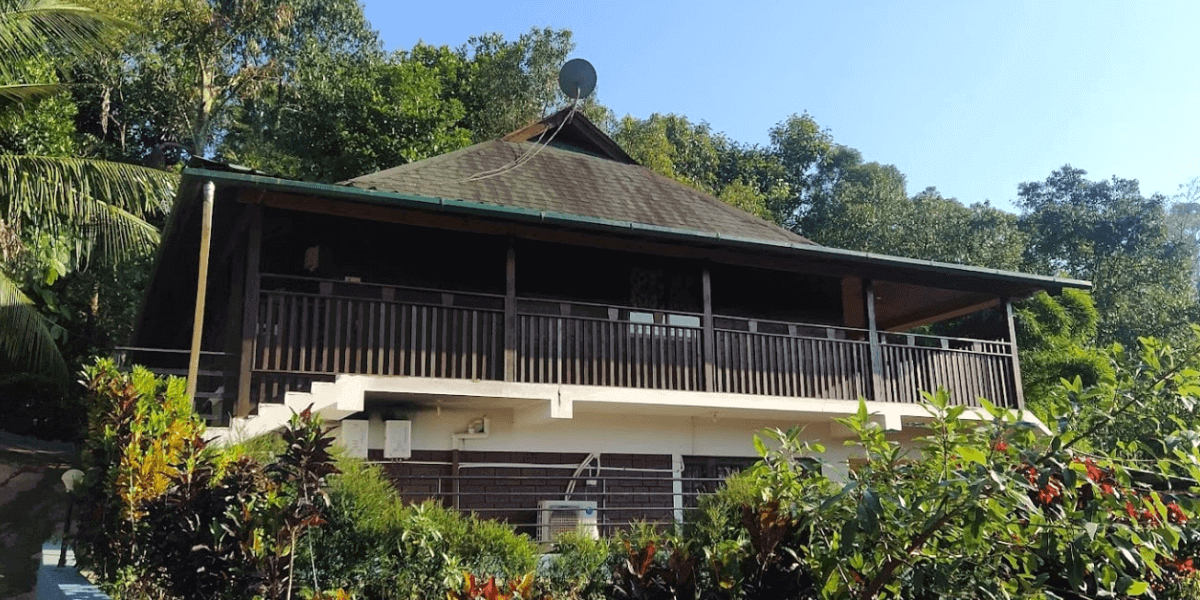 A house with a balcony, located near Bynekaadu Resort, showcasing its inviting architecture and scenic surroundings.