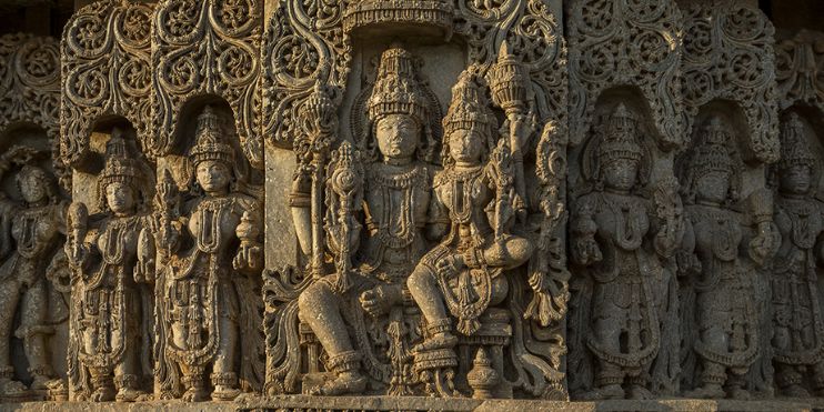 Carvings of Hindu gods adorn the side of a Hoysala temple, showcasing intricate artistic details and cultural significance.