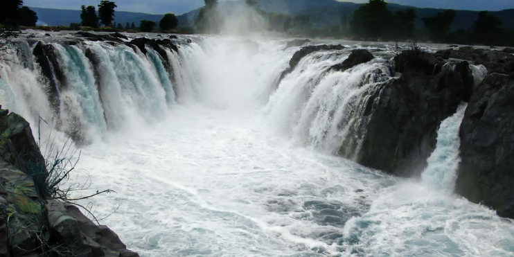 A large waterfall cascades down at Hogenakkal Falls, showcasing nature's beauty, especially during the monsoon season.