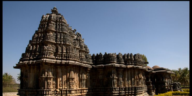 Stone temple with intricate carvings, showcasing Hoysala craftsmanship, set in a serene environment near Koravangala.