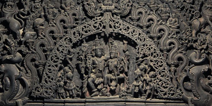 A large, intricately carved wooden structure showcasing detailed designs, reflecting the artistry of the Hoysala dynasty.