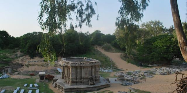 Aerial view of an ancient temple surrounded by dense forest, showcasing the archaeological site of Talakadu.
