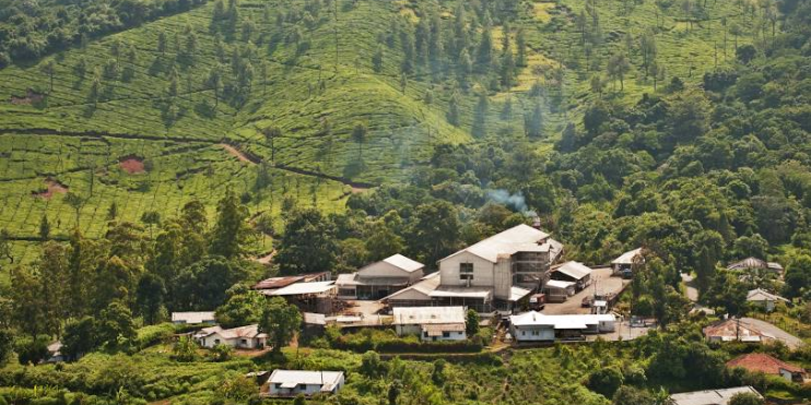 A small village nestled among lush green hills and trees, showcasing a serene rural landscape.