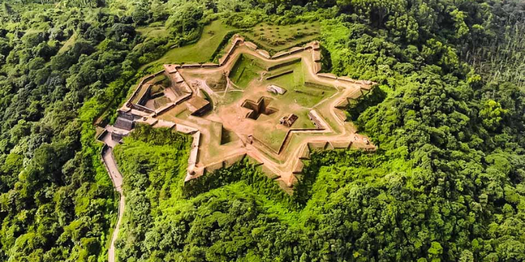 Aerial view of a star-shaped castle surrounded by lush green forest in Sakleshpur, a scenic gem in the Western Ghats.