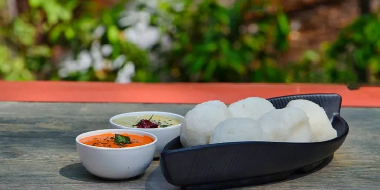 A bowl of rice accompanied by a small bowl of sauce, set on a table, representing Malnad cuisine's earthy flavors.