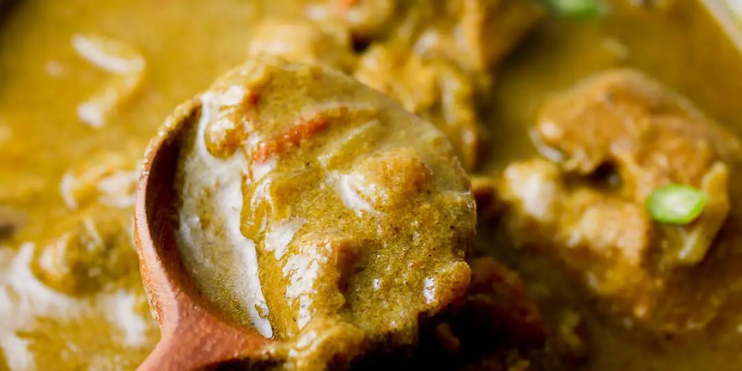 Chicken curry with green peas served in a bowl, showcasing vibrant colors, a popular street food in Chikmagalur.